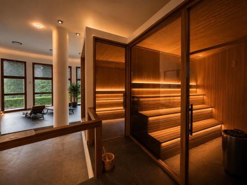 ein Zimmer mit Holzwänden und ein Flur mit einem Stuhl in der Unterkunft Pawlow History Hotel in Wolkenstein