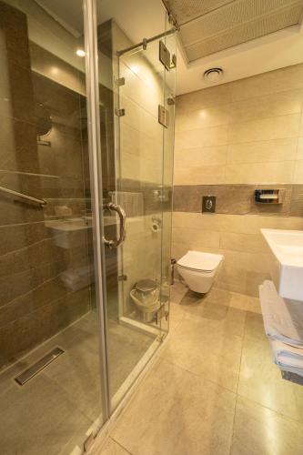 a bathroom with a glass shower and a toilet at Maadi Hotel in Cairo