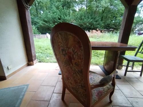 a bird sitting on a chair next to a table at Maison indépendante studio calme et confort in Ervauville