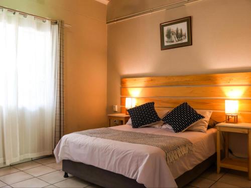 a bedroom with a bed with two pillows on it at Kruger Foothills Lodge - Near Kruger National Park in Hoedspruit