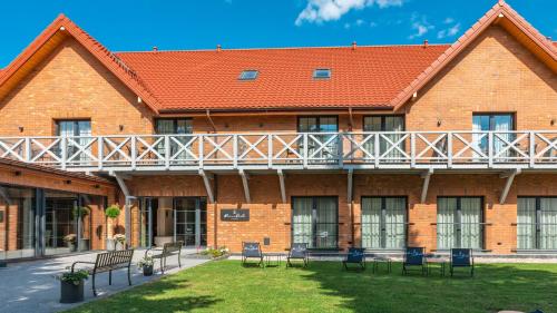 a large brick building with chairs and a balcony at Marina Piaski Apartamenty in Piaski