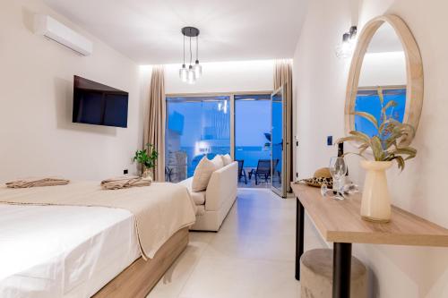 a bedroom with a bed and a table and a mirror at Blue Horizon Studios in Laganas