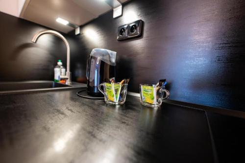 a kitchen counter with two cups on a counter top at Factory Suites in Prague