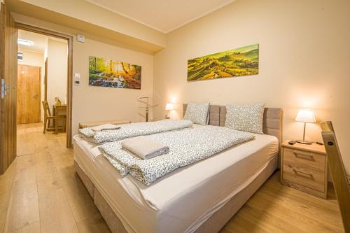 a bedroom with a large white bed in a room at Palmy Home Ecser in Ecser