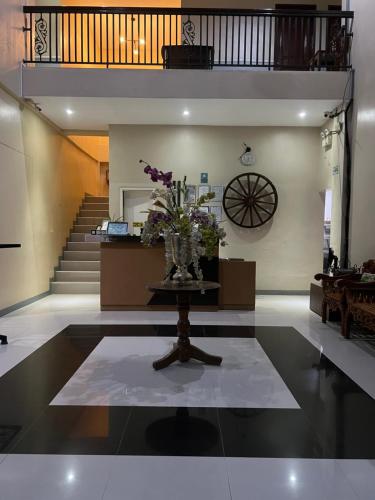 a lobby with a vase of flowers on a table at B&S Orchids Suites Hotel in Dipolog