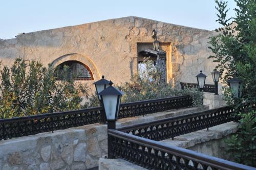 a building with a stone wall and a street light at Kemerli Konak Boutique Hotel in Kérynia