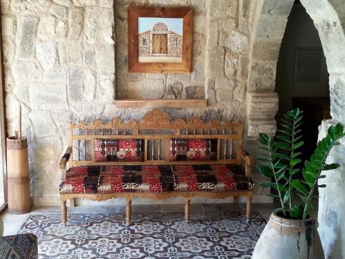 a bedroom with a bench in a stone wall at Kemerli Konak Boutique Hotel in Kérynia