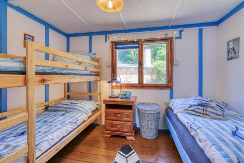 a bedroom with two bunk beds and a window at Modrobílá chatka u rybníka in Holoubkov