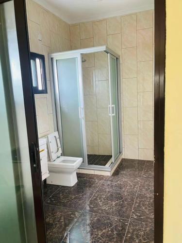 a bathroom with a toilet and a glass shower at Roof View Macaneta in Praia de Macaneta