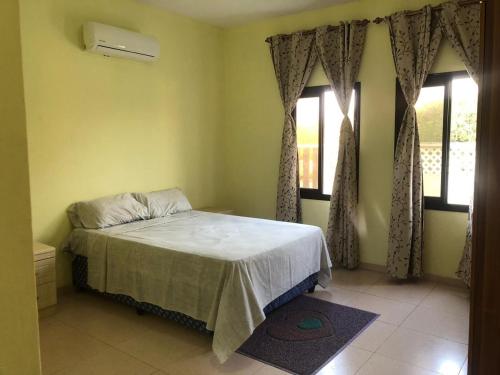 a bedroom with a bed and two windows at Roof View Macaneta in Praia de Macaneta