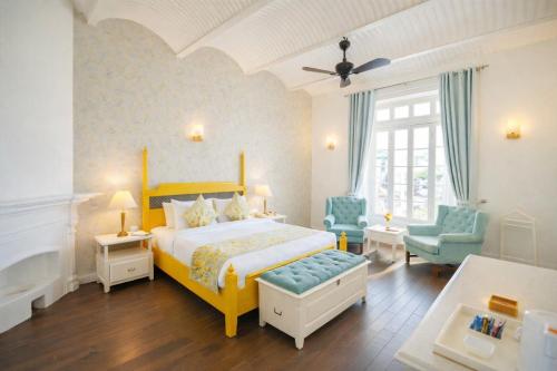 a bedroom with a bed and two blue chairs at Pine Retreat - A Premium Heritage Property in Mussoorie