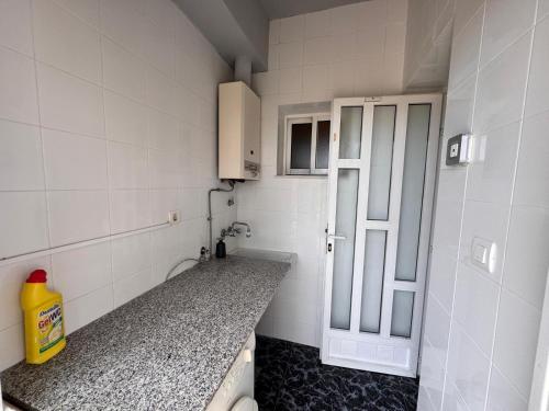 a small bathroom with a sink and a door at Mirador de Bolnuevo in Bolnuevo