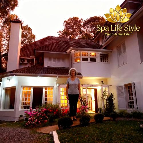 a woman standing in front of a house at SPA LIFESTYLE Centro de Bem Estar in Canela