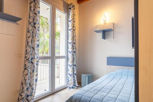 a bedroom with a bed and a large window at Villa Ulivi Private Pool & Lake View in Montinelle
