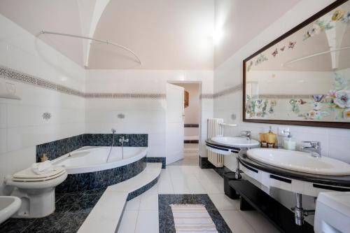 a bathroom with two sinks and a tub and a toilet at Masseria Lamapecora in Faccia di Trippa