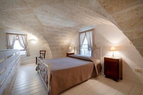 a bedroom with a bed and two windows at Masseria Lamapecora in Faccia di Trippa