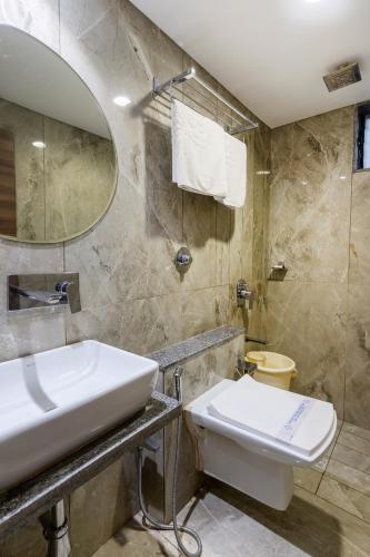 a bathroom with a sink and a toilet at Hotel Ashish in Ahmedabad