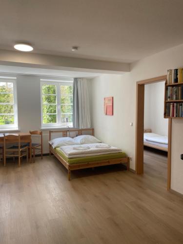 a bedroom with a bed and a table and two windows at VITA Ferienresidenz in Neu Kaliß