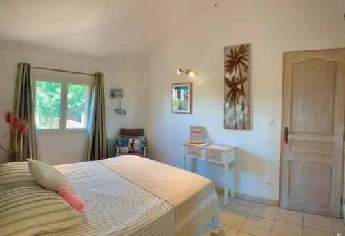 a bedroom with a bed and a table and a window at Villa Flamingo GAYmen only b&b in Marseillan