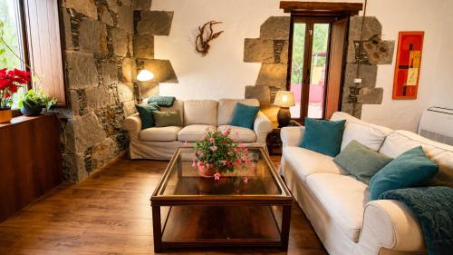 a living room with two couches and a table at Finca La Acequia del Gamonal in Santa Brígida