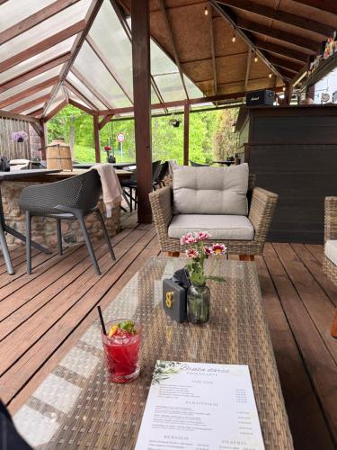 acovered patio with a table and chairs on a wooden deck at Park Hotel Brūzis in Smiltene