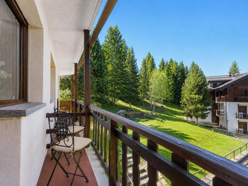 a balcony with two chairs and a view of a yard at Hostdomus - Clotes Dream Suite in Sauze d'Oulx
