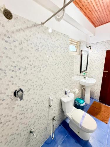 a bathroom with a toilet and a sink at Happy Night Holiday Inn in Unawatuna