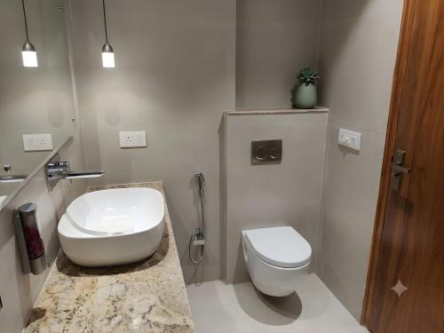 a white bathroom with a toilet and a sink at Sawarthia Sewa Sadan, Ayodhya in Ayodhya