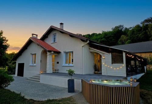 a white house with a pool in front of it at La Maison aux pieds des Pyrénées - Piscine d'exception de 25m in Espoey