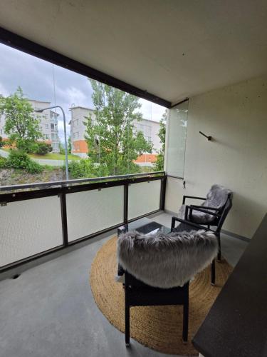 a room with two chairs and a large window at Studio at Tottinkatu in Savonlinna