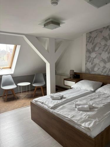 a bedroom with a large bed with two towels on it at Hotel Polonia in Ostrów Wielkopolski