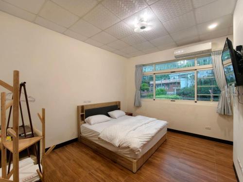 a bedroom with a bed and a window at Hongpeng Coffee Station Homestay in Meishan