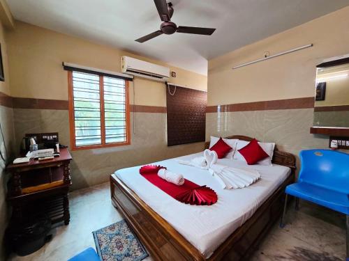 a bedroom with a bed with a fan and a blue chair at Anandaloke Guest House in Kolkata