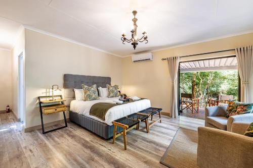 a bedroom with a bed and a living room at Mazuri Bush Cottages in Hluhluwe