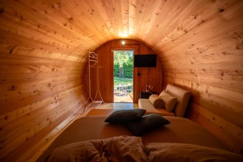 a room with a large bed in a wooden cabin at Rifugio diVino Dormire in una botte - Wine Barrel stay near Rome in Rieti