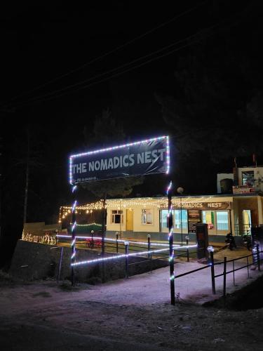 a sign that reads the mondlords nest at night at The nomadics nest in Bhadarwāh