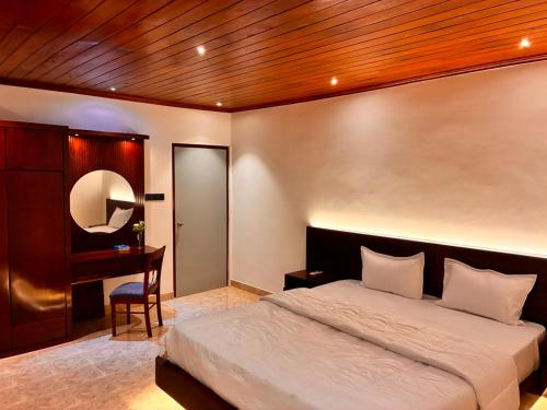 a bedroom with a large bed and a desk at Lullaby Marine Villa in Wadduwa