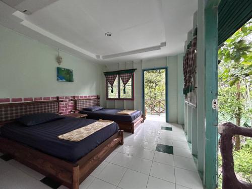 a bedroom with two beds and a window at Chill Out Bar and Bungalows in Tonsai Beach