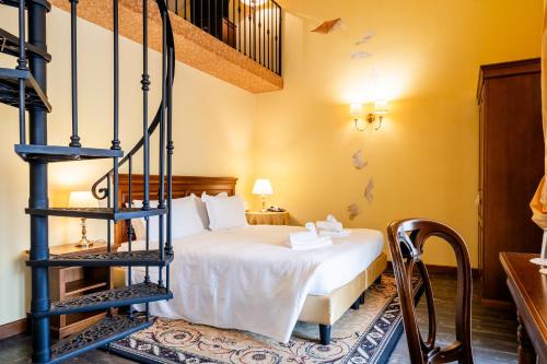 a bedroom with a bed and a spiral staircase at Hotel Serenella in Sirmione