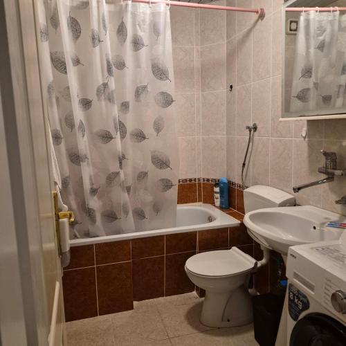 a bathroom with a toilet and a tub and a sink at Bright & Spacious Apartment Budva in Budva