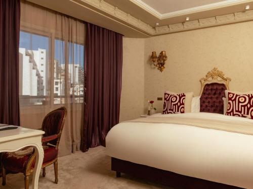 a bedroom with a bed and a desk and a window at Art Palace Suites & Spa in Casablanca