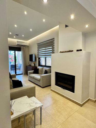 a living room with a couch and a fireplace at Ionian Waves Villa - Marathopoli Stylish Escape in Marathopoli