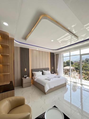 a bedroom with a large bed and a large window at Milano Villas Puncak in Puncak