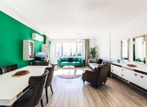 a living room with green walls and a table and chairs at Melissas Suites Lara in Antalya
