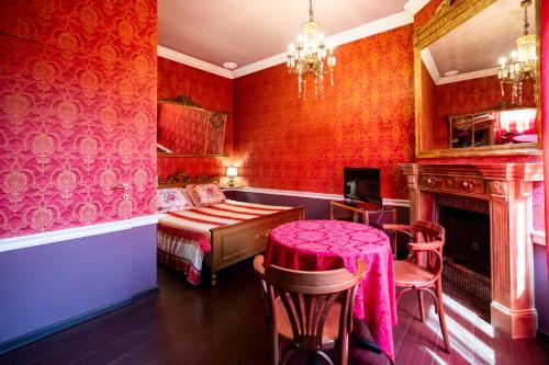 a red room with a bed and a table and chairs at Rubra in Santerno