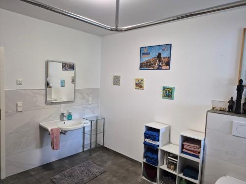 a bathroom with a sink and a mirror at Ferienhaus "Pusteblume" - Entspannen in Weiterode in Bebra