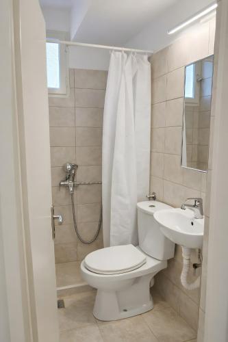 a bathroom with a toilet and a sink at Value Double Lower – Room 12 in Gouvia