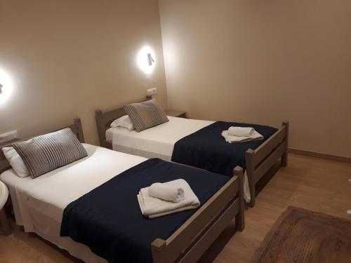a room with two beds with towels on them at Value Double Lower – Room 12 in Gouvia