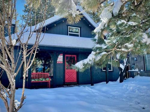 a building with a red door in the snow at THE OHANA at BIG BEAR in Big Bear City