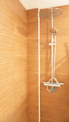 a shower in a bathroom with a wooden wall at Amazing apartment direct pool acces in Denia